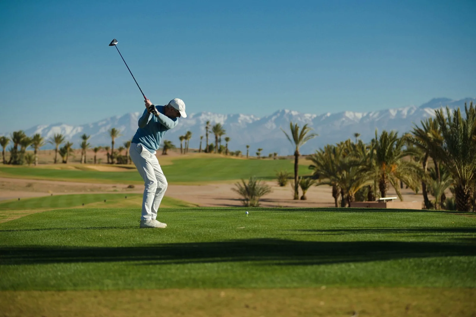Golfeur professionnel en plein swing sur un parcours de golf à Marrakech